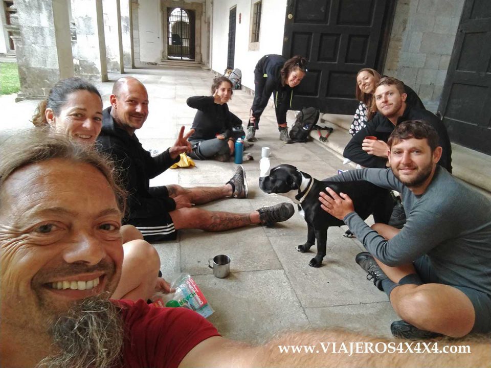 Amigos y peregrinos sentados en el suelo en el Camino de Santiago